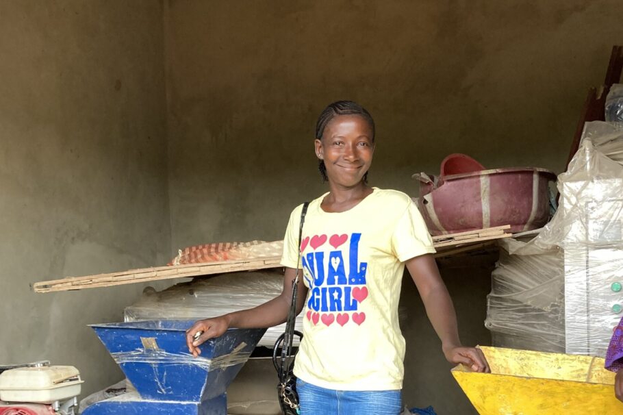 A woman stands in front of machinery