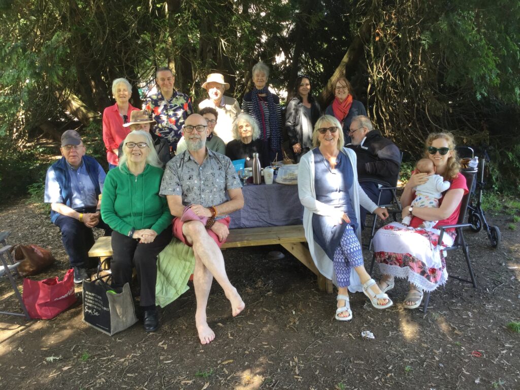 A large crowd gathers around a picnic table