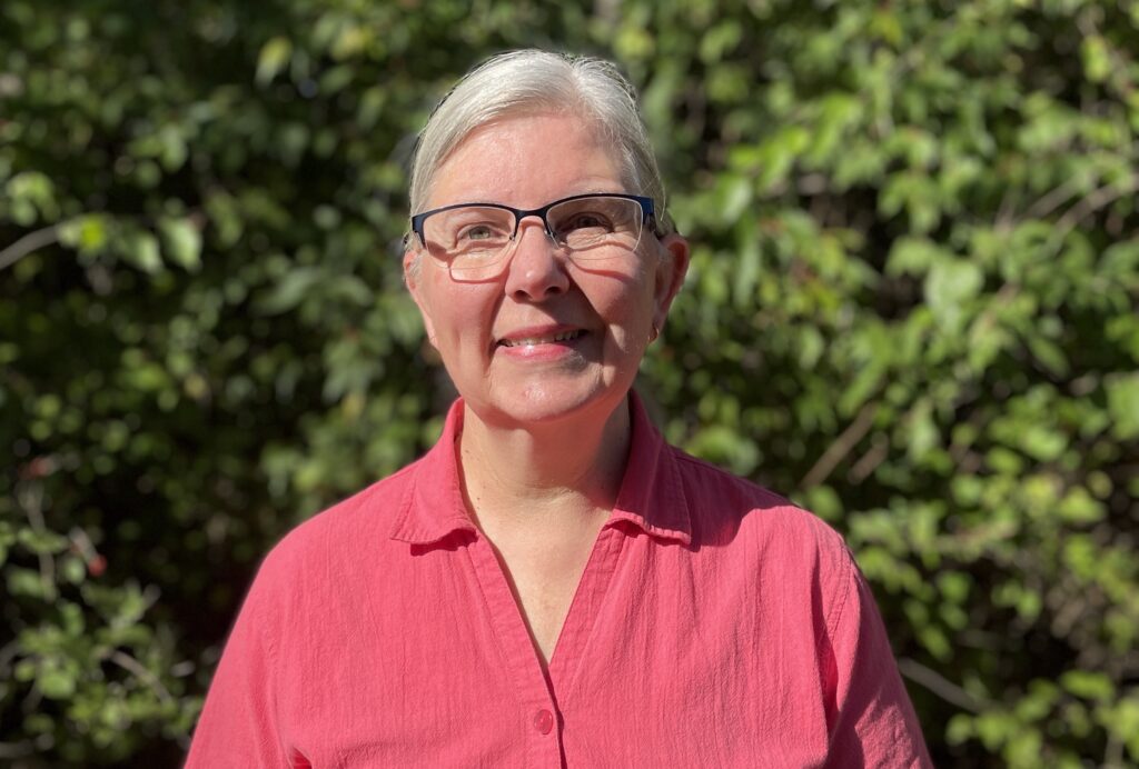 Katrina stands in front of greenery